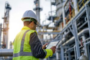 Engineer with a tablet at an oil refinery